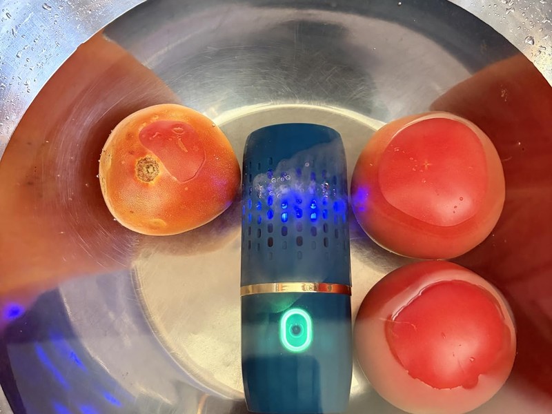 PurePod with blue LED cleaning tomatoes in a steel bowl